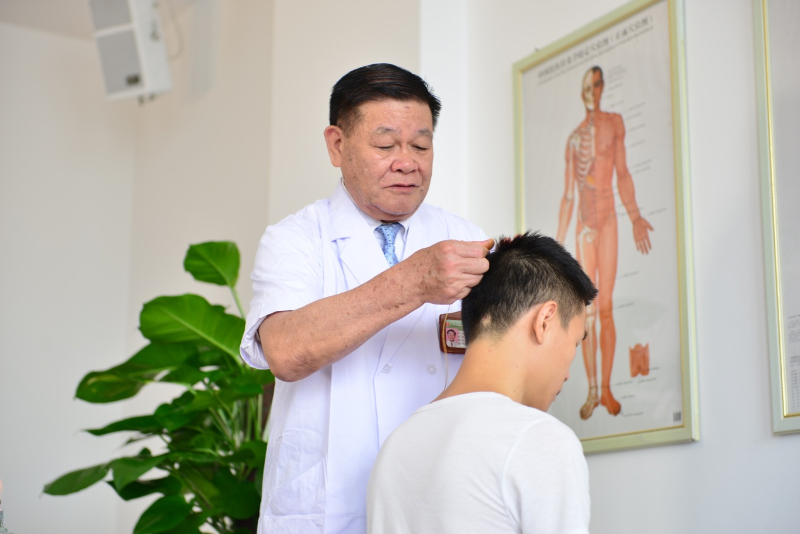 国医大师黄瑾明为患者进行壮医药线点灸疗法治疗。kaiyun登录中国入口登录供图